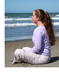 Woman Meditating In The Beach 